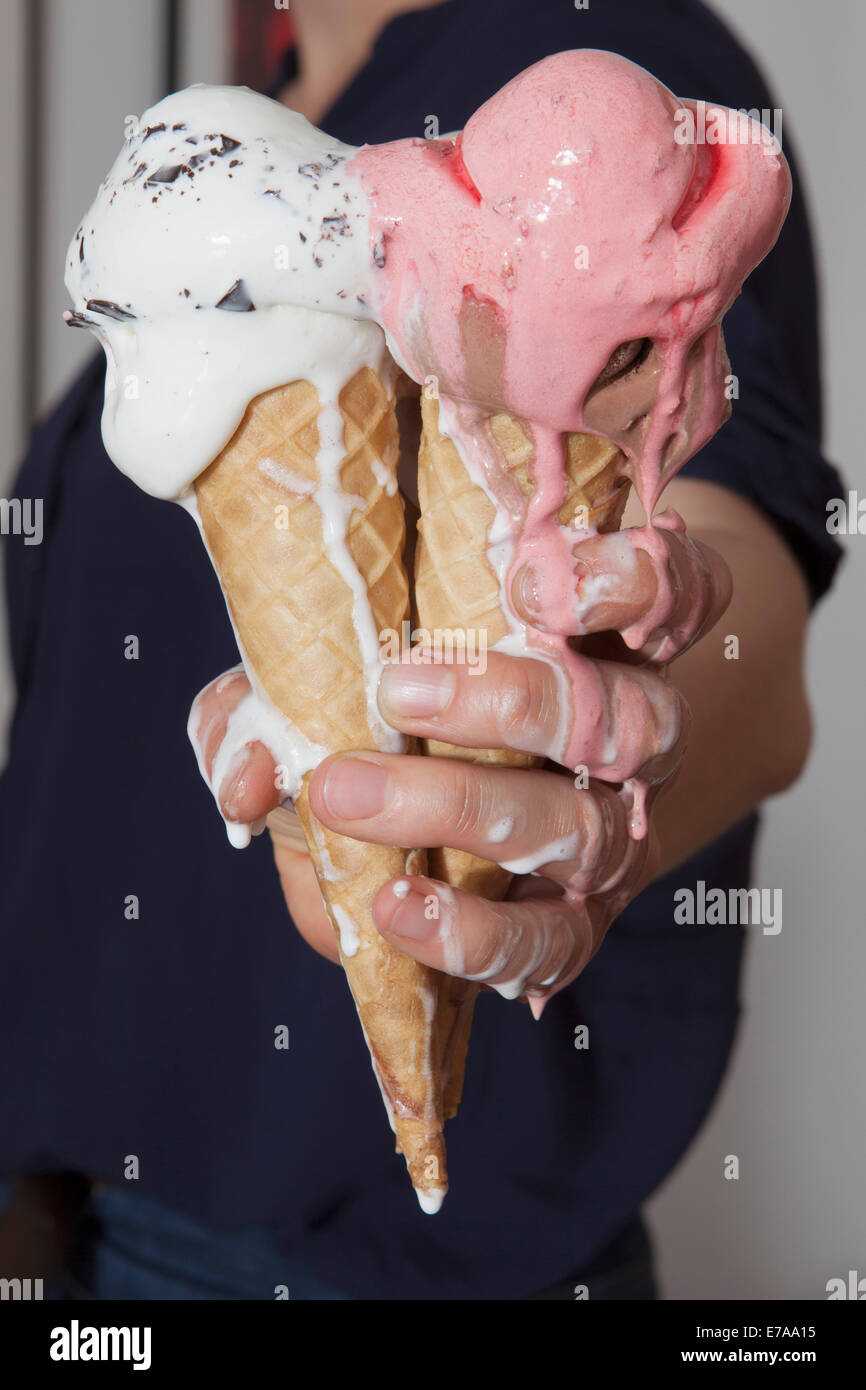 Midsection of senior woman holding melting ice cream cones at home Stock Photo