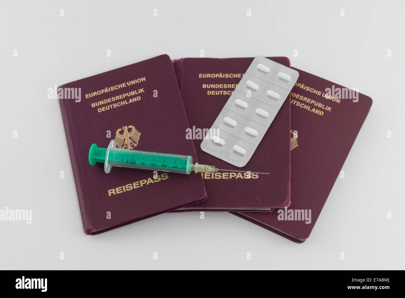 Disease Control: German passports with syringe and tablets Stock Photo