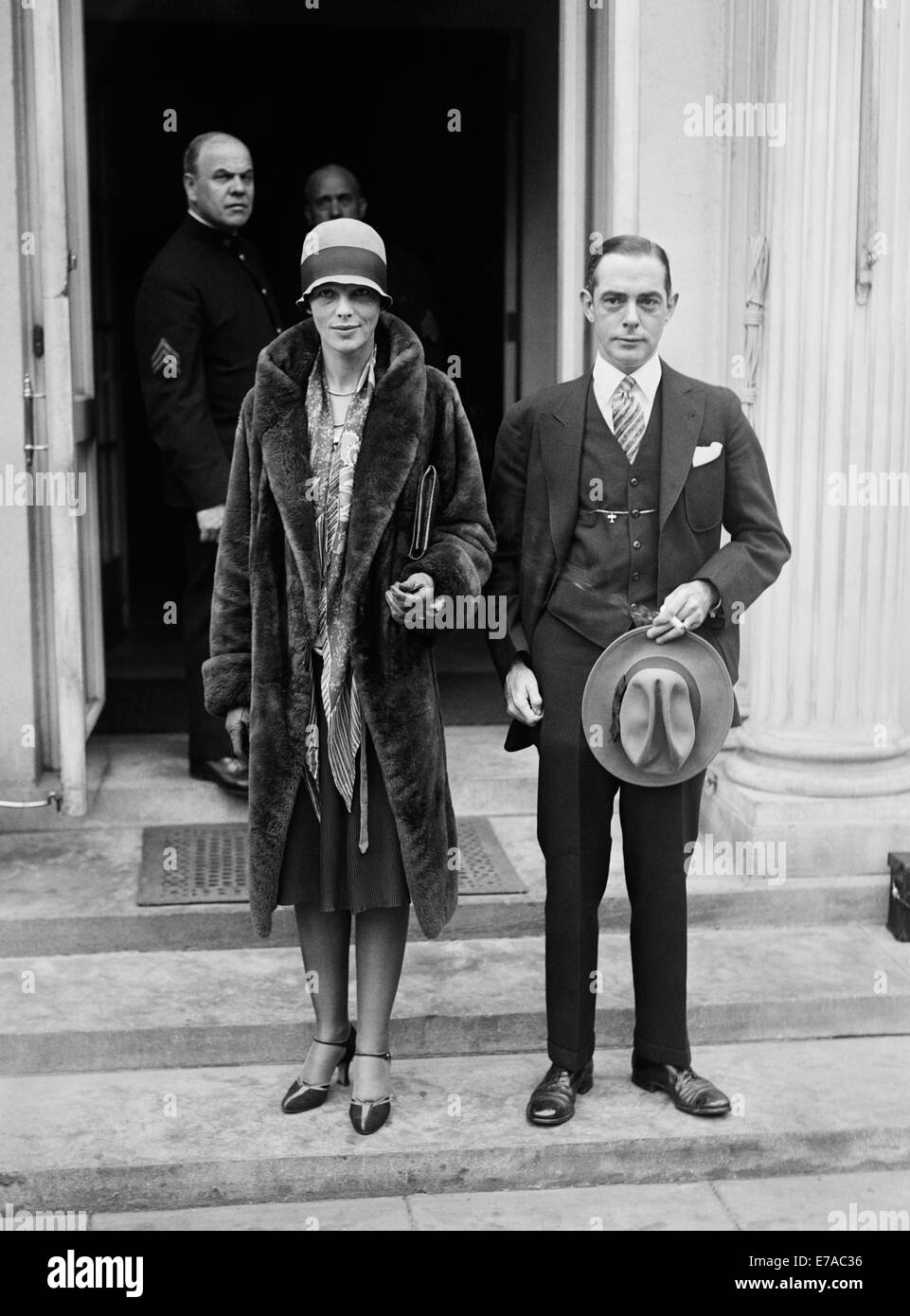 Vintage photo of American aviation pioneer and author Amelia Earhart (1897 – declared dead 1939) – Earhart and her navigator Fred Noonan famously vanished in 1937 while she was trying to become the first female to complete a circumnavigational flight of the globe. Earhart is pictured in November 1928 outside The White House during a visit to see President Calvin Coolidge. Alongside her is Porter Adams, President of the National Aeronautic Association. Stock Photo