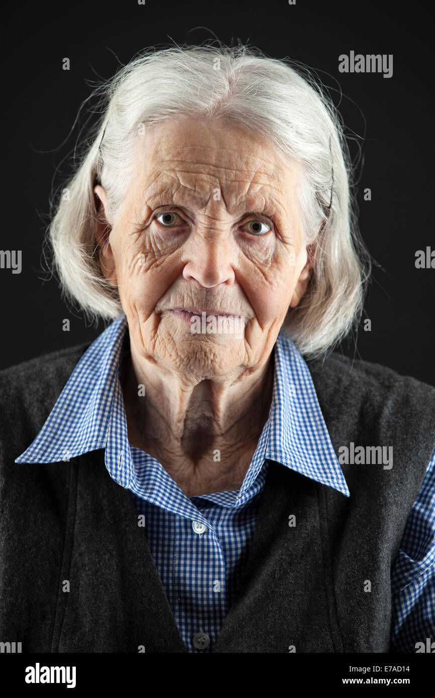 Portrait of a calm senior woman looking at the camera. Over black ...