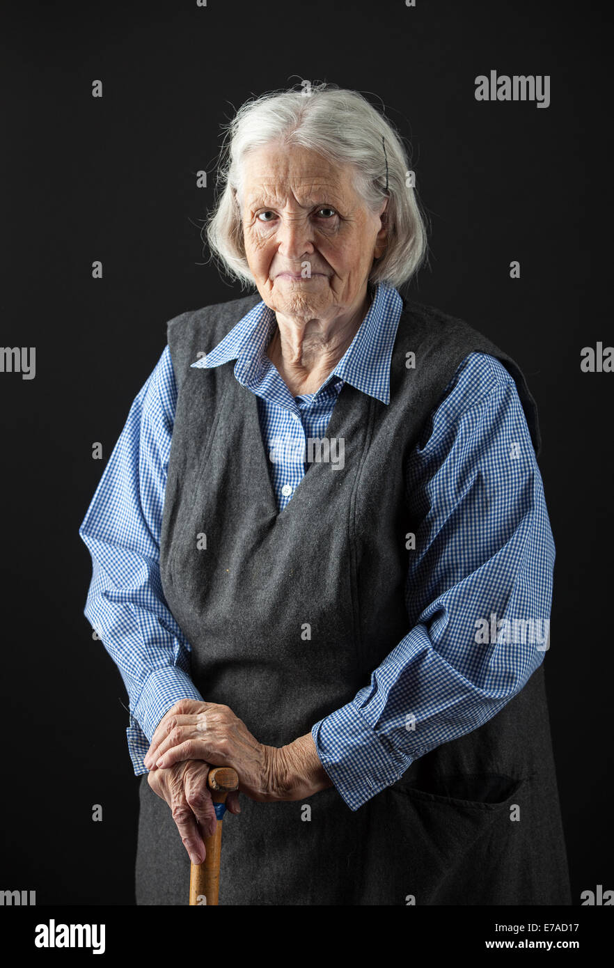 Portrait of a smiling senior woman looking at the camera. Over black ...