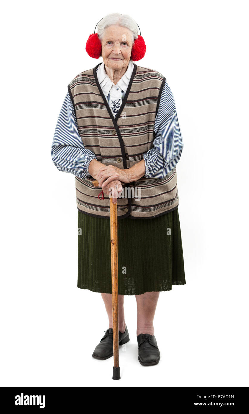 Old woman with a cane wearing red faux fur ear muffs over white Stock Photo