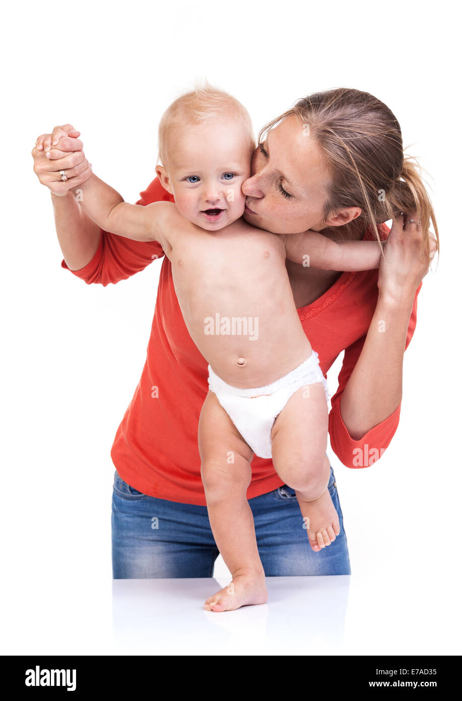 Baby boy learning to walk with mother's help over white Stock Photo
