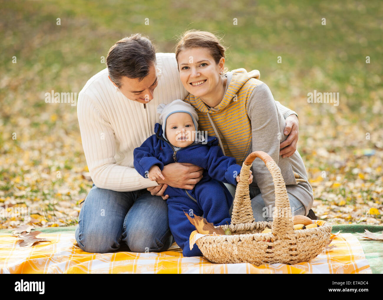 Young couple with baby boy on picnic in autumn park Stock Photo