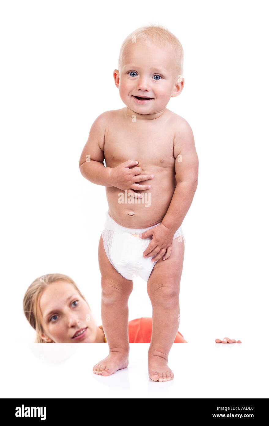 Mother watching her baby boy making first steps over white background Stock Photo