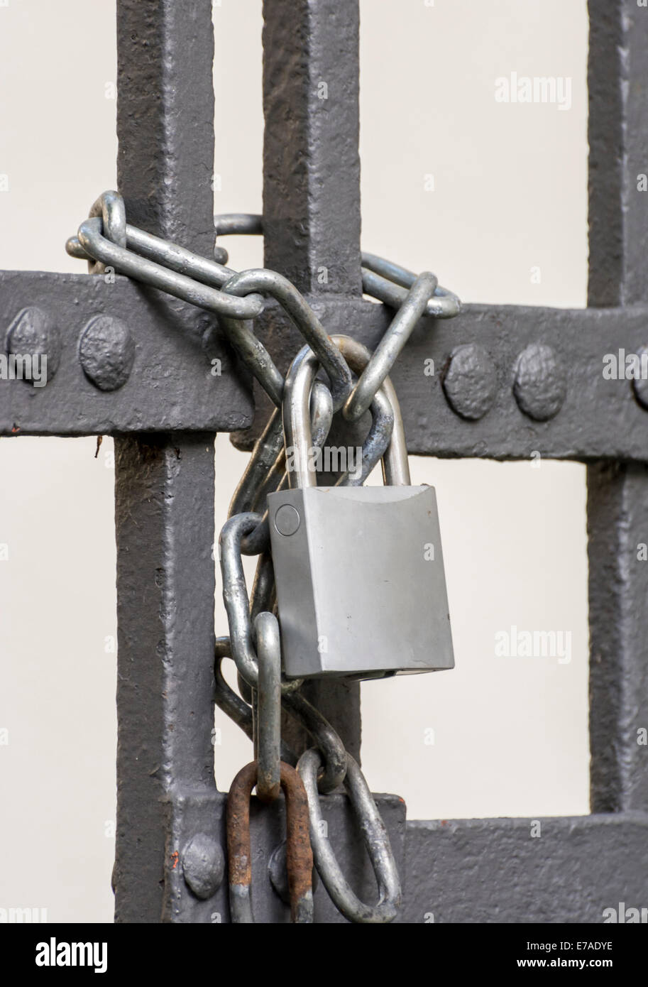 Iron gate scured with a chain and a padlock Stock Photo - Alamy