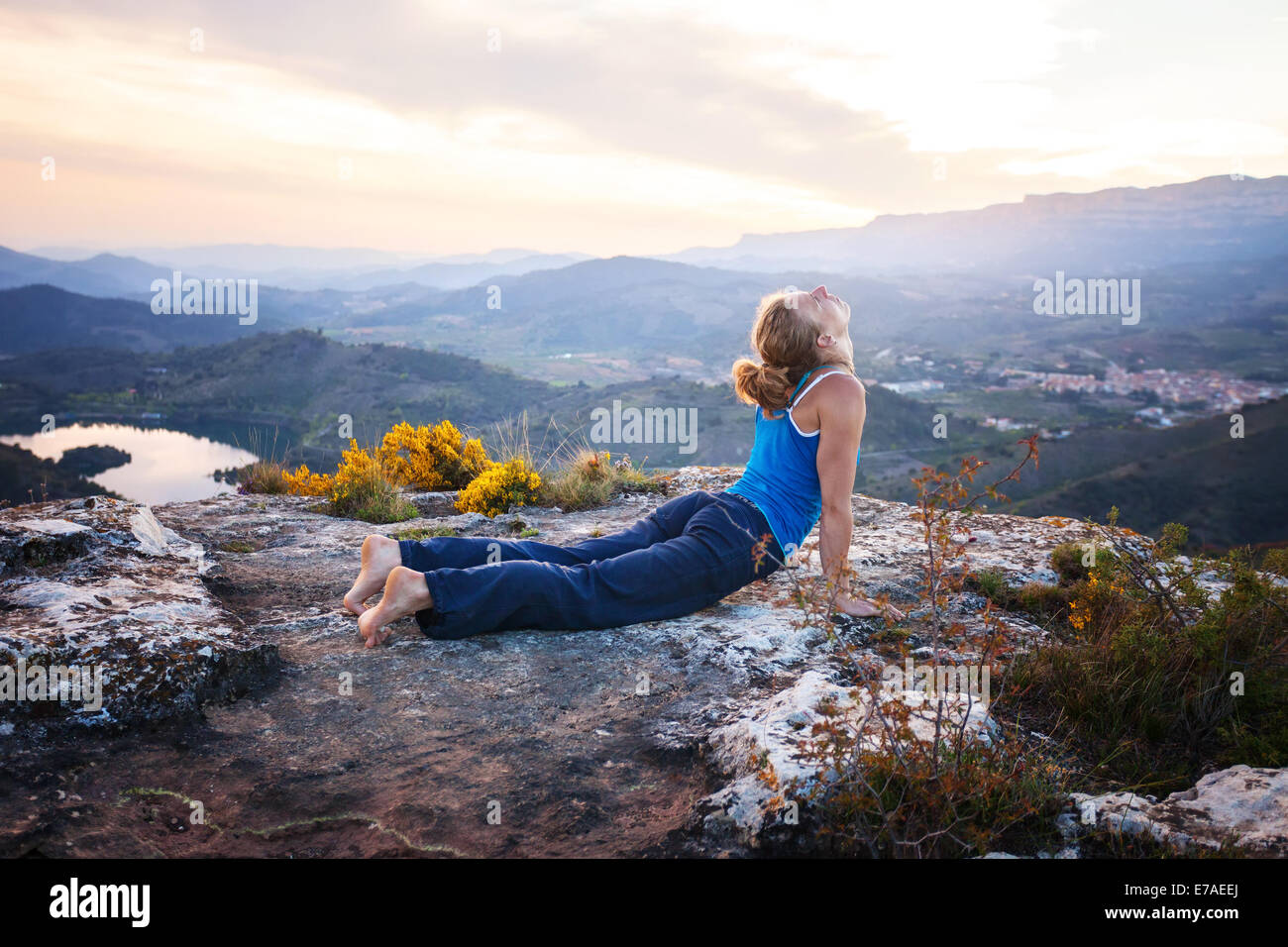 Young Caucasian woman performing upward facing dog pose outdoors Stock Photo