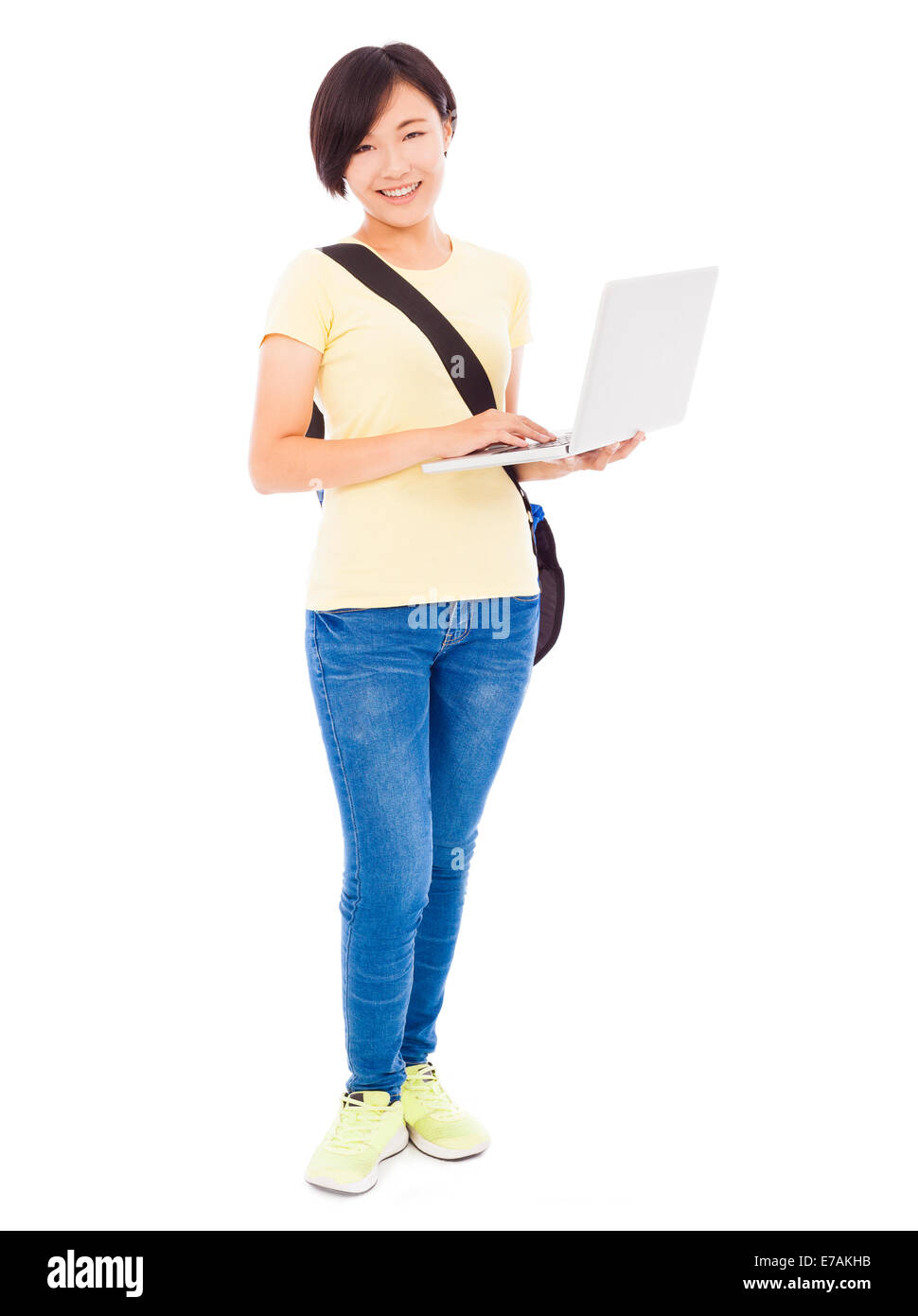 Smiling young woman holding a laptop over white background Stock Photo