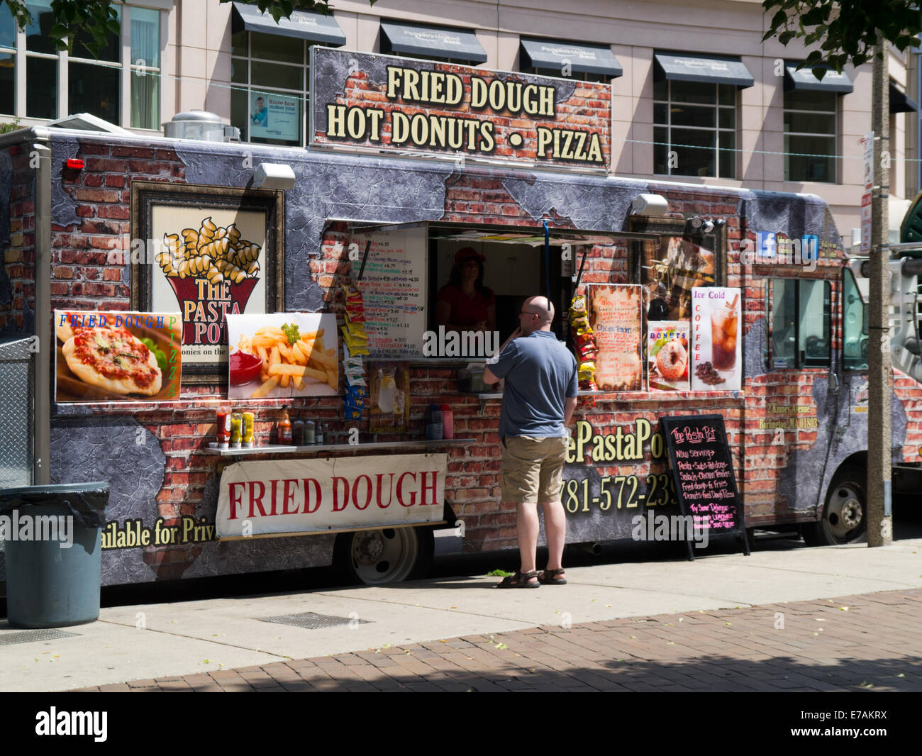 man standing at Fast Food take away van selling fried dough hot donuts pizza  Boston  Massachusetts, USA Stock Photo