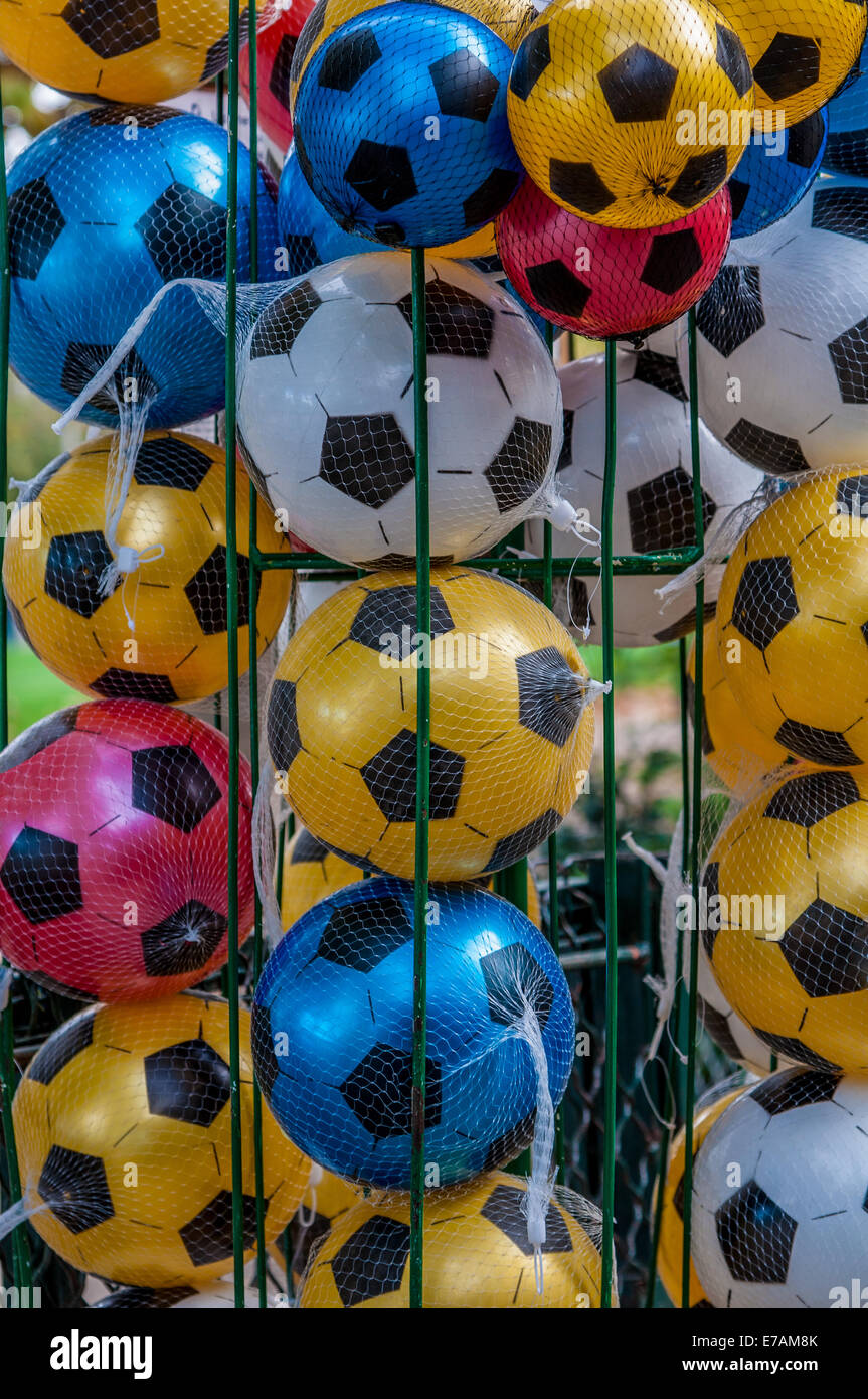 Colorful footballs/soccer balls are stacked in a cage ready for use. Stock Photo