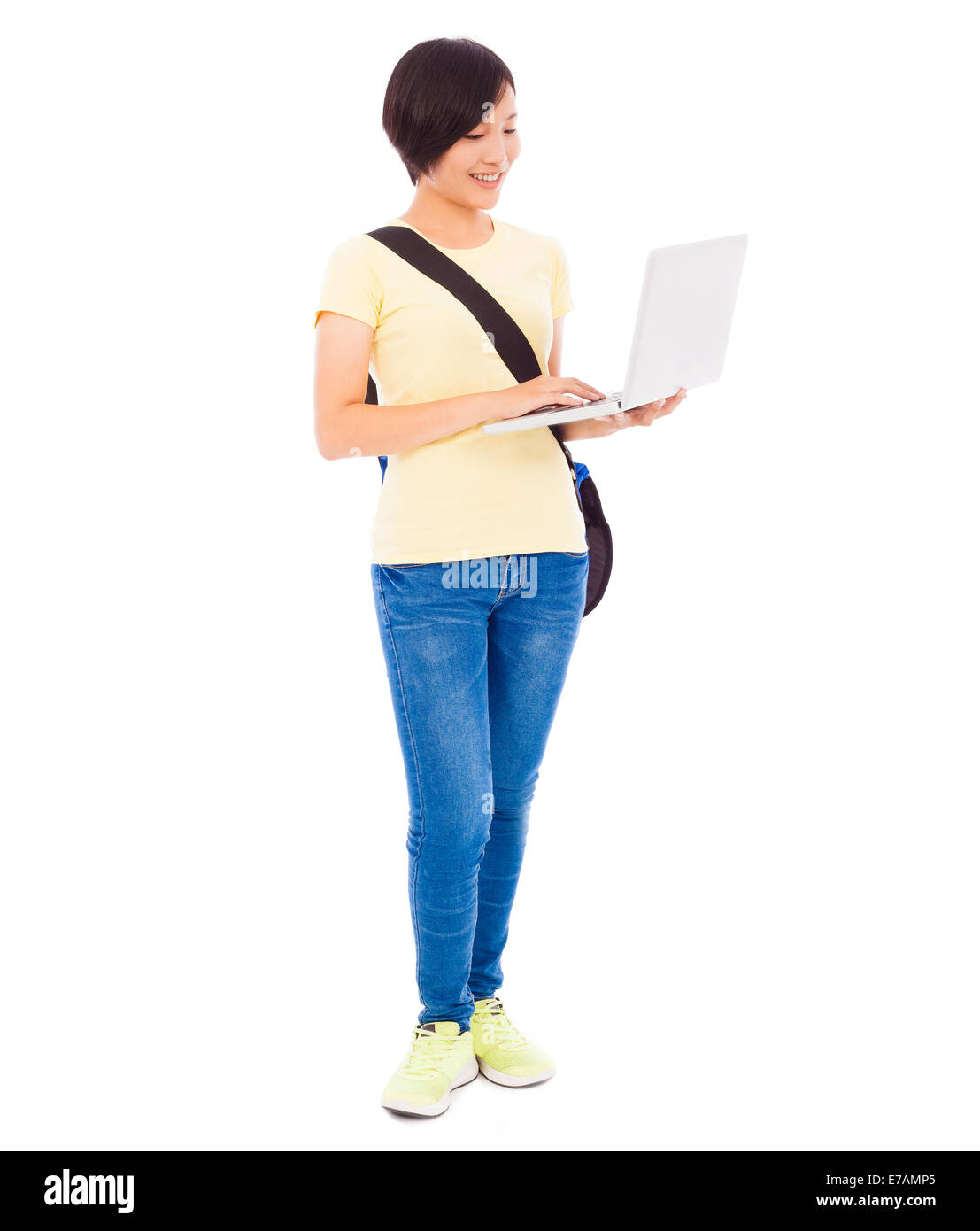 young student girl standing and  holding a laptop over white background Stock Photo
