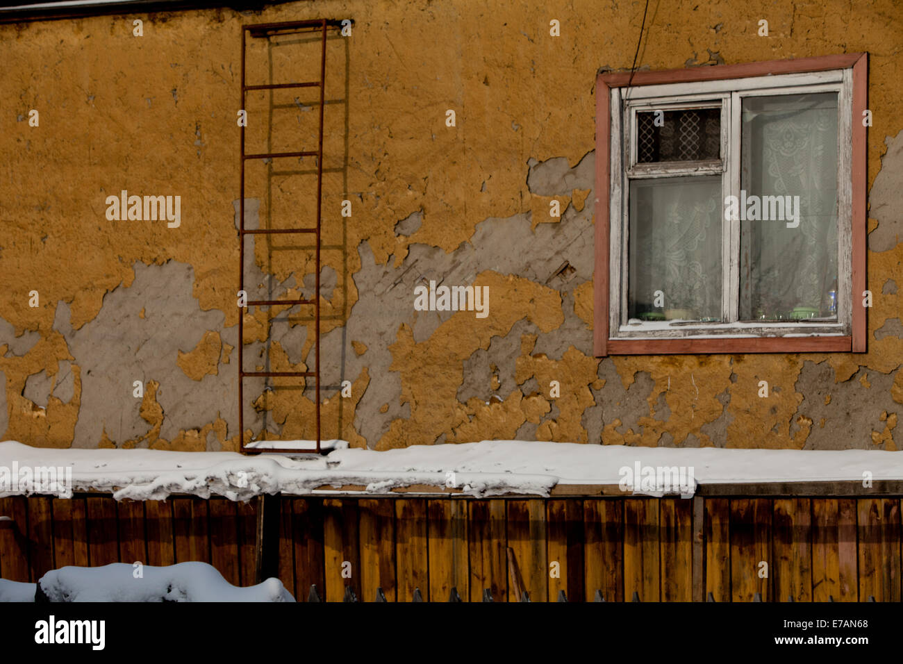 tired wall crumbling plaster window ladder snow Stock Photo