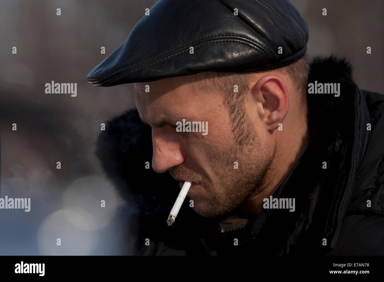 cool russian man smoking leather cap Stock Photo