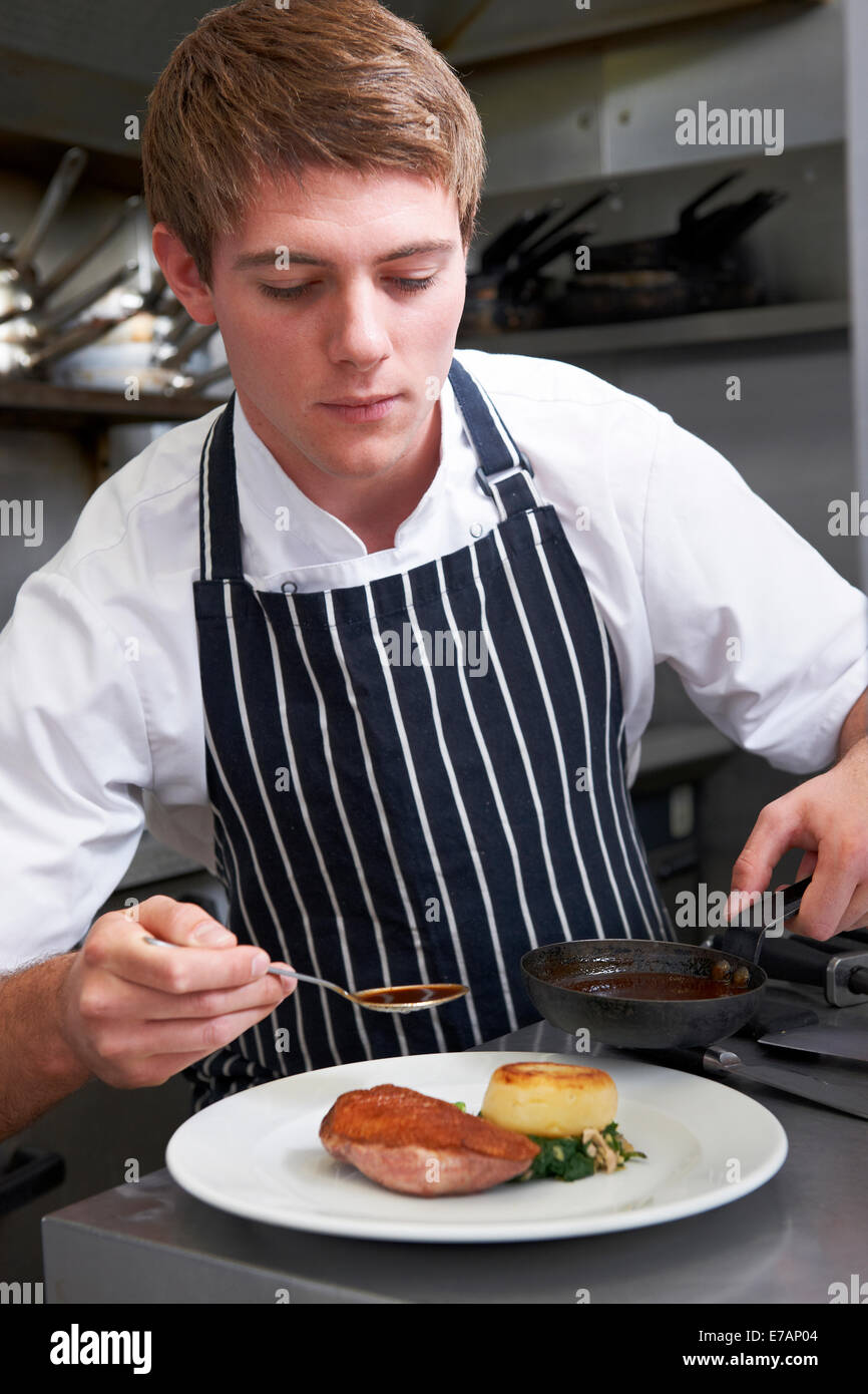 Male Chef Preparing Meal In Restaurant Kitchen Stock Photo