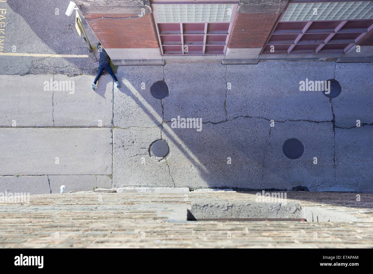 An unconscious person lying face down at the side of an alley Stock Photo