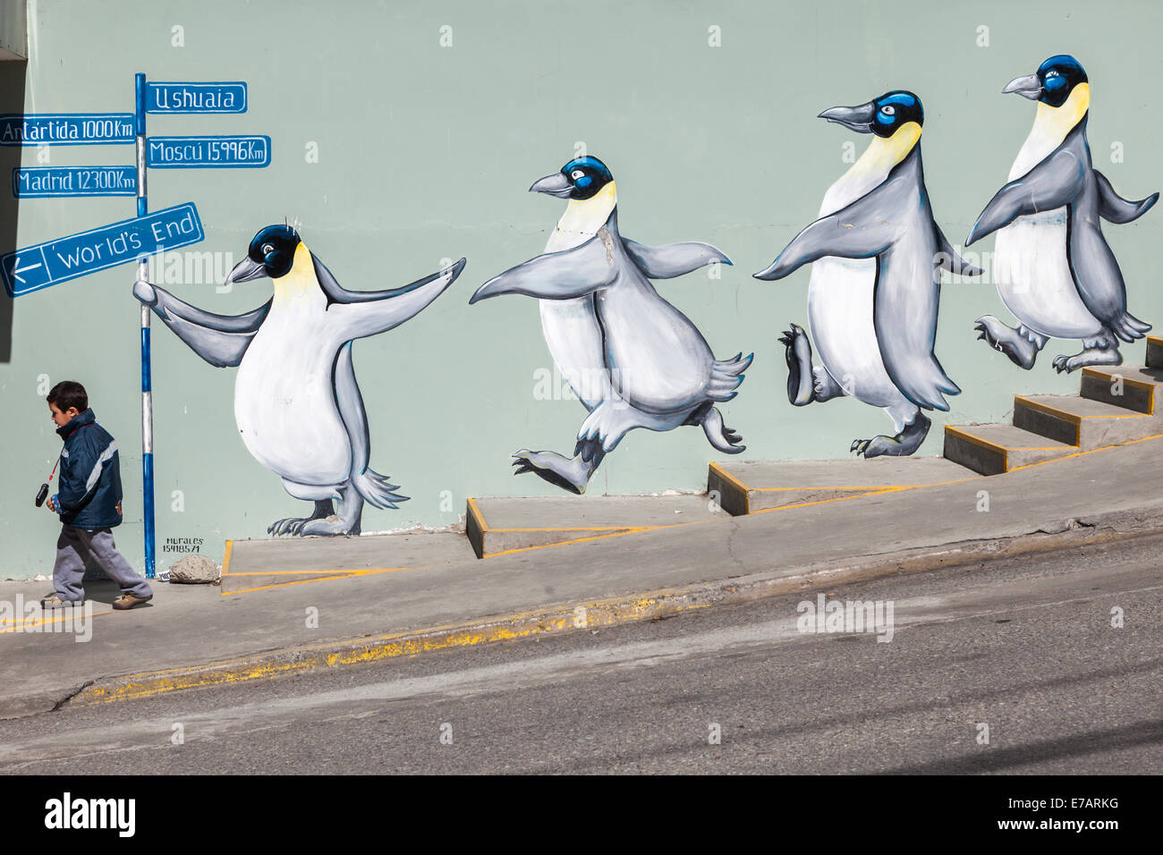 A child walkin in front of a penguin mural in Ushuaia, Argentina Stock Photo