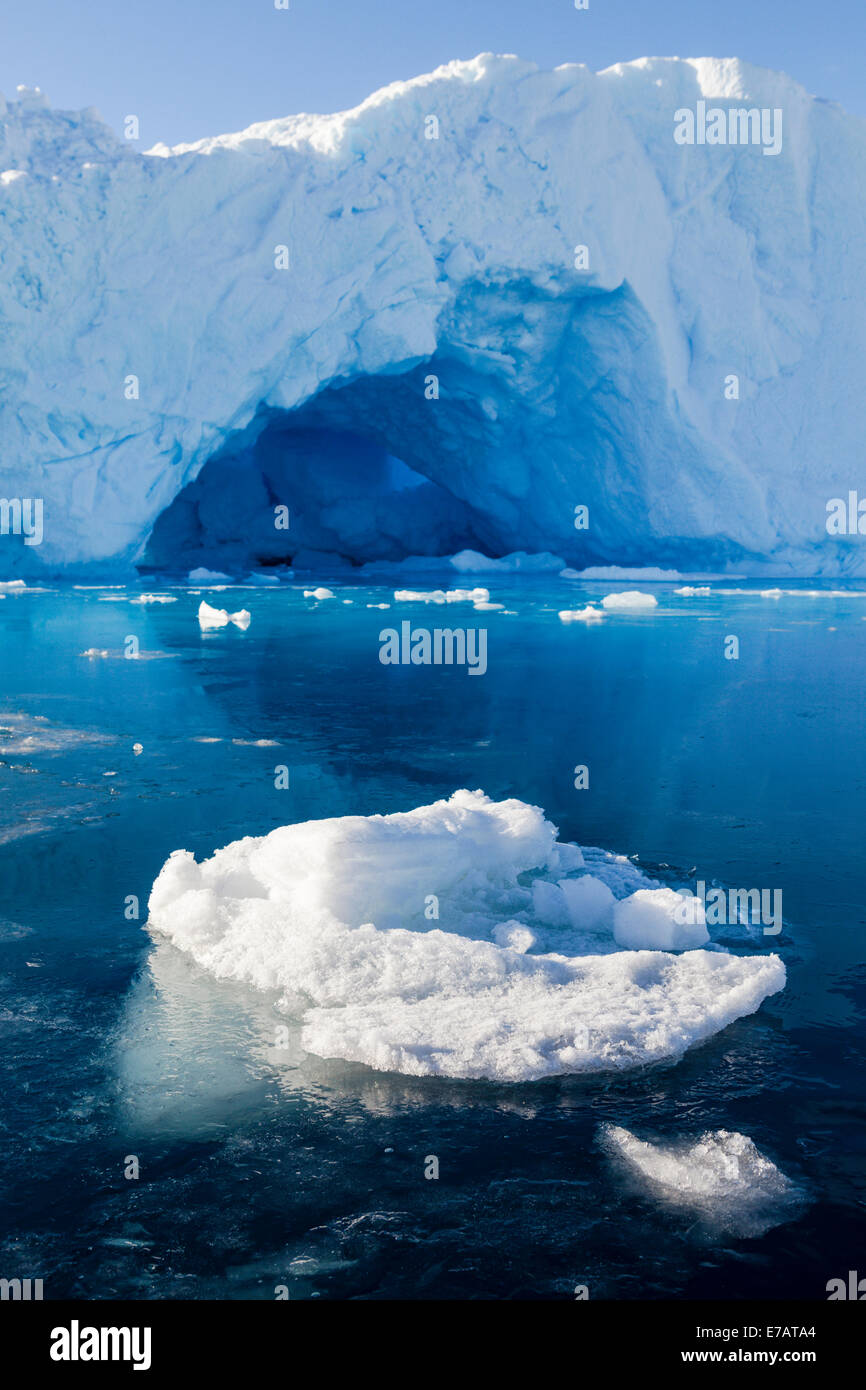 Frozen ocean surface, ice blocks and iceberg arch near Fish Islands, Antarctica Stock Photo