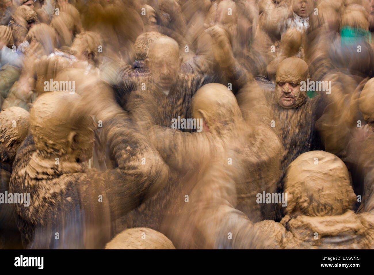 Shiite Muslim men, covered in mud, in trance, chanting and self-flagellating during Ashura Day, in Bijar, Iran. Stock Photo