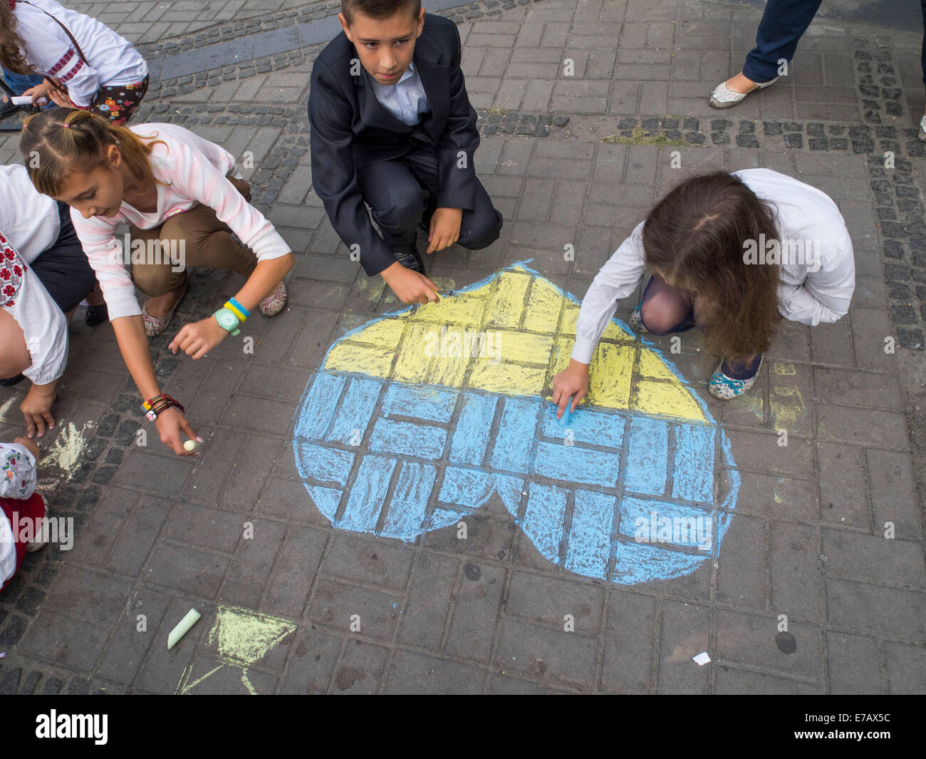 Kiev, Ukraine. 11th Sep, 2014. The action began with patriotic drawings on asphalt. A dozen children of all ages, dressed in embroidered, painted on the square near the monument to the flags of Ukraine and the yellow-blue heart, and wrote the national motto, 'Glory to Ukraine!'. -- Today in Kiev a few dozen activists and students came to the monument to the victims of terrorism, in order to honor the memory of those killed during the terrorist attack in New York on September 11, 2001. Credit:  Igor Golovnov/Alamy Live News Stock Photo