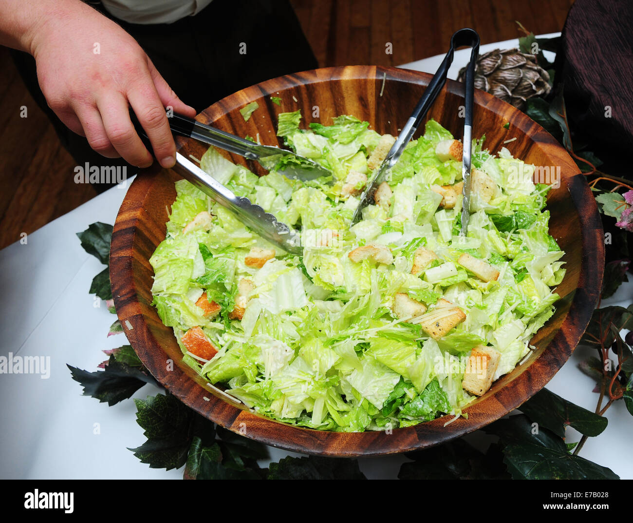 A Caesar salad being served at a buffet, Stock Photo
