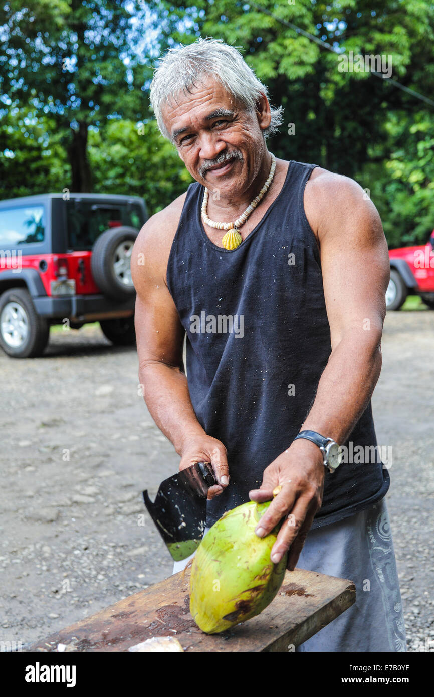 Coconut vendor David Kaaumoang sells fresh coconuts on Kauai to tourists visiting the North Shore Stock Photo