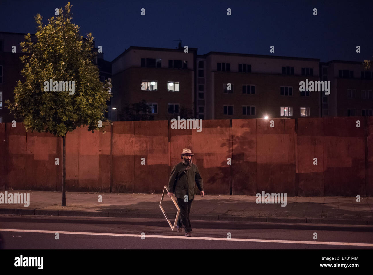 London, UK. 11 September 2014: A man holding a wooden frame crosses Kingsland Road in Dalston, North-East London. Credit:  Piero Cruciatti/Alamy Live News Stock Photo