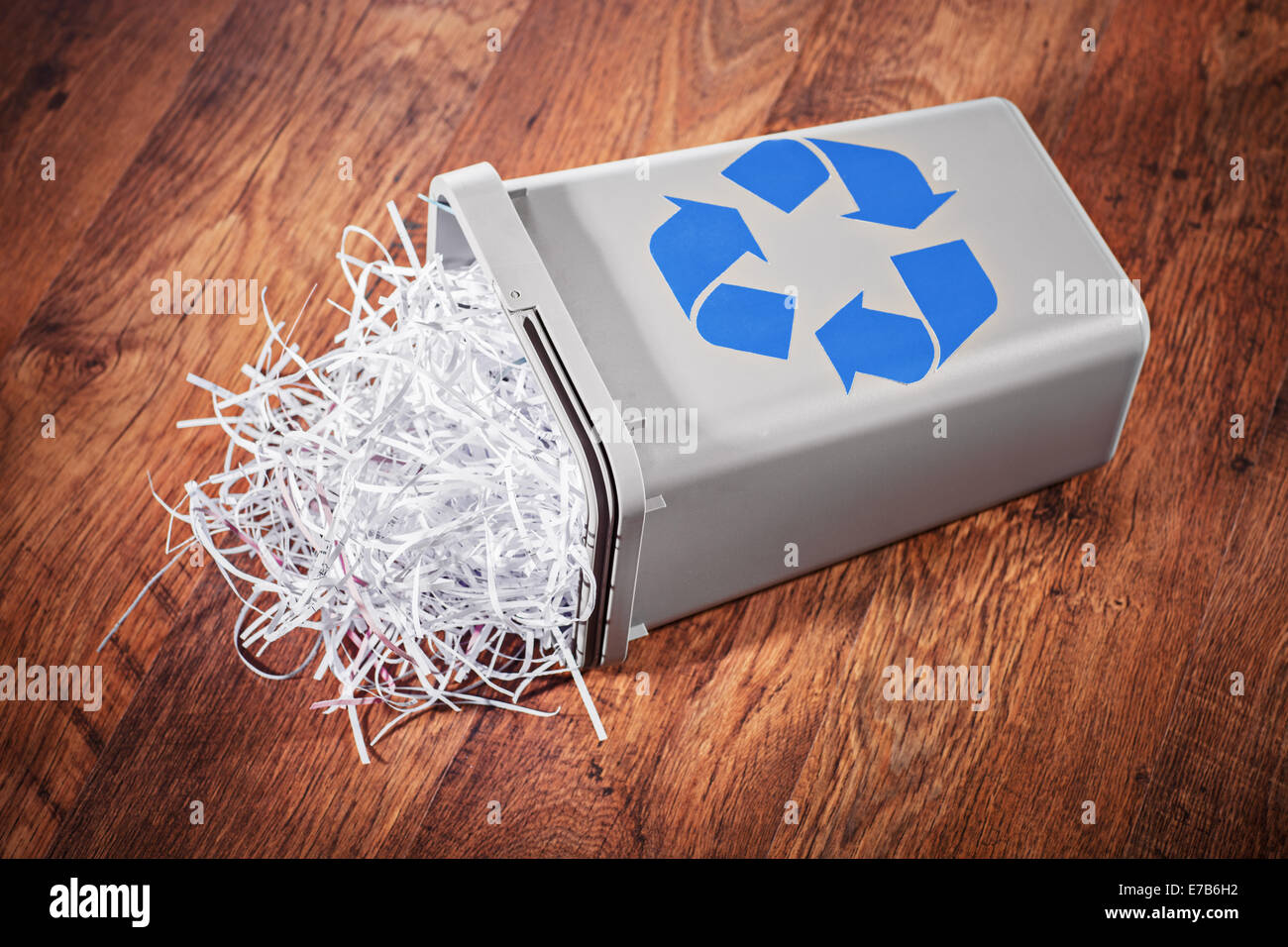 Flipped recycle bin full of shredded paper on a wooden floor Stock Photo -  Alamy