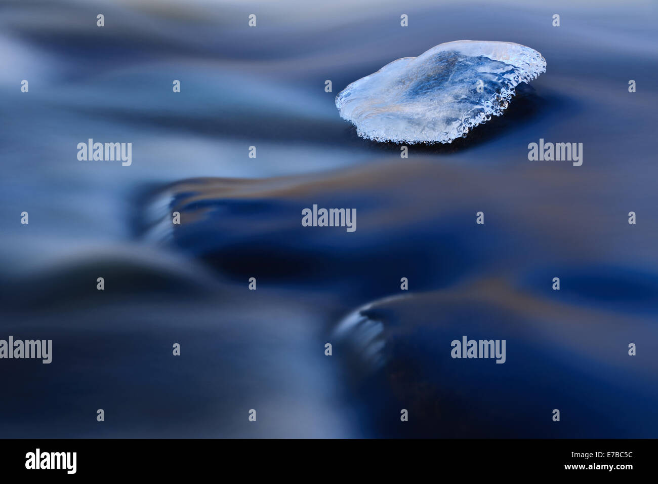 Ice on a smooth rock in river. Stock Photo