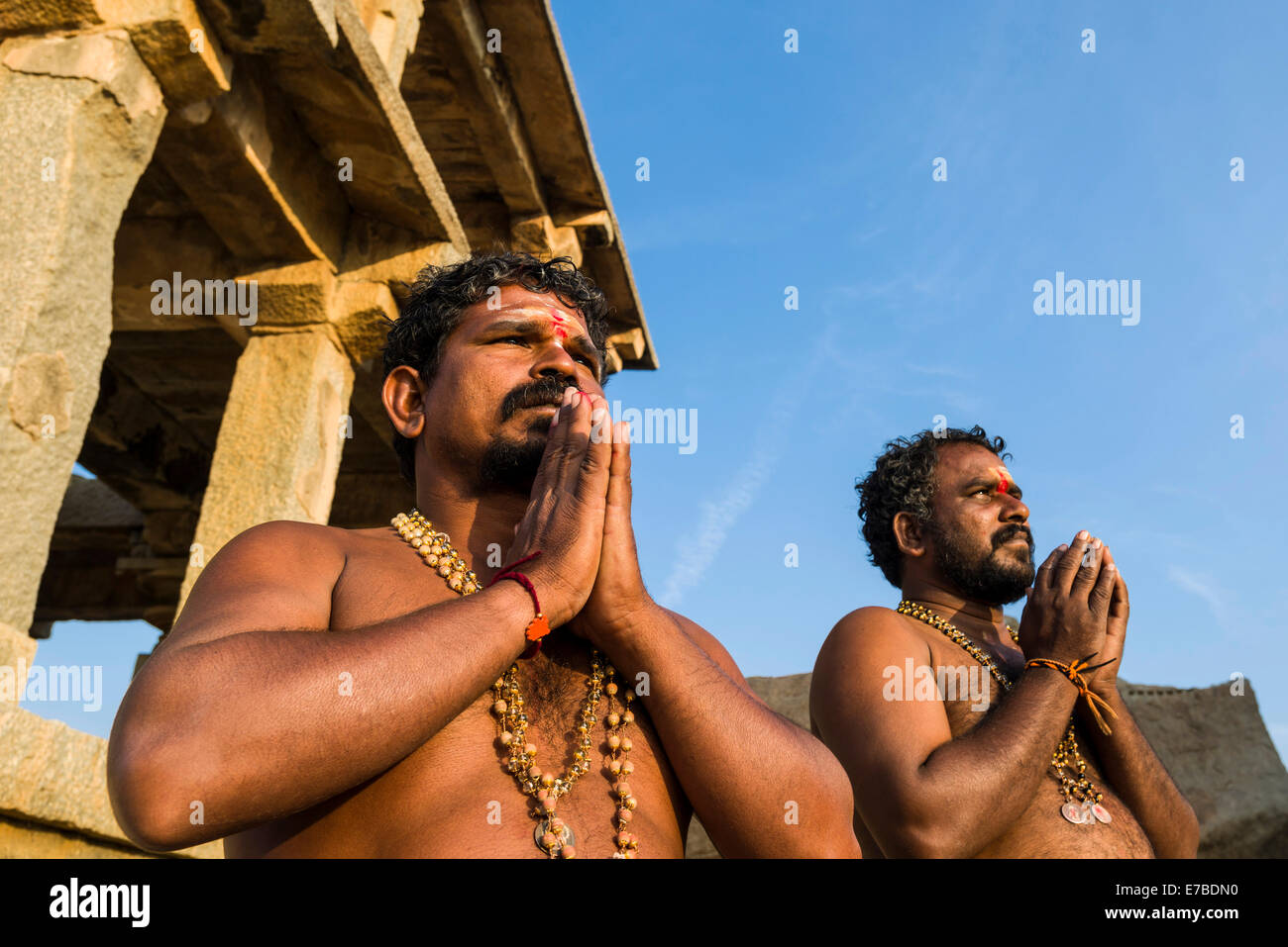 Devotees praying at a temple on Hemakuta Hill, ruined city of Vijayanagara, UNESCO World Heritage Site, Hampi, Karnataka, India Stock Photo