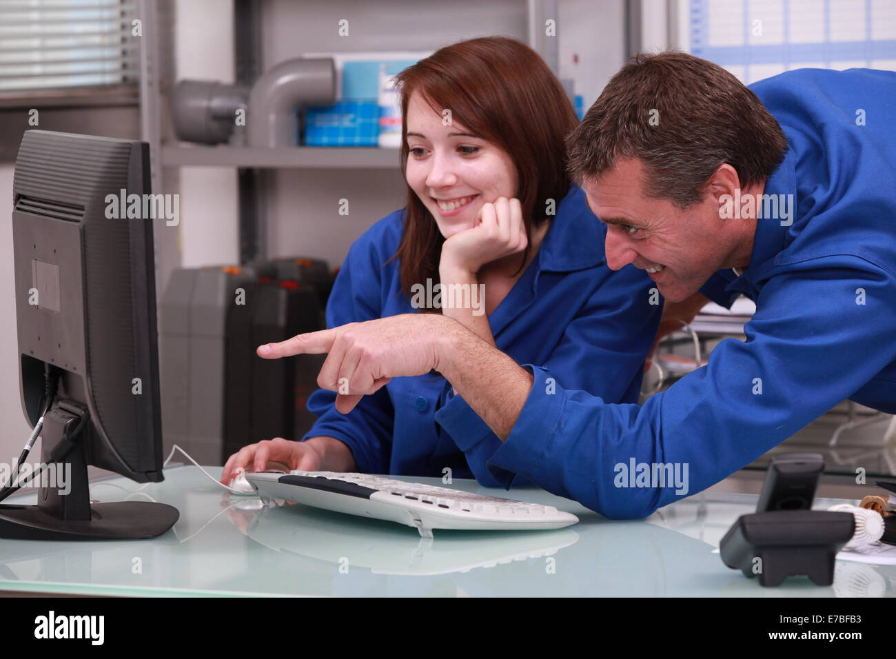 two colleagues in blue jumpsuits Stock Photo