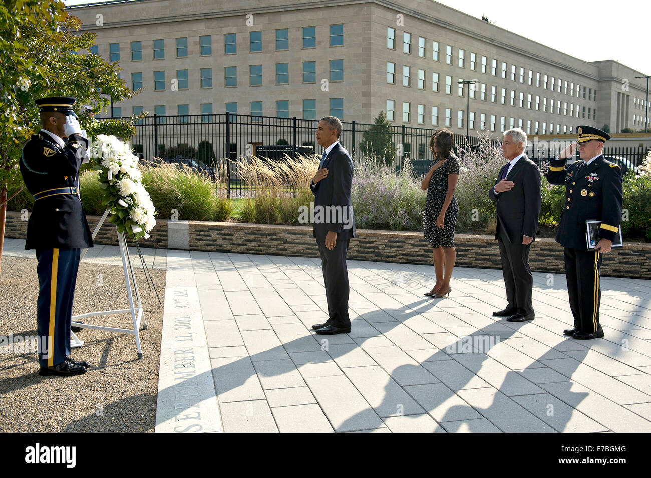 US President Barack Obama, First Lady Michelle Obama, Defense Secretary Chuck Hagel and Joint Chiefs Chairman General Martin Dempsey pay respects after placing a wreath in honor of the victims during the anniversary commemoration of the 9/11 terrorist attacks at the Pentagon September 11, 2014 in Arlington, Virginia. Stock Photo