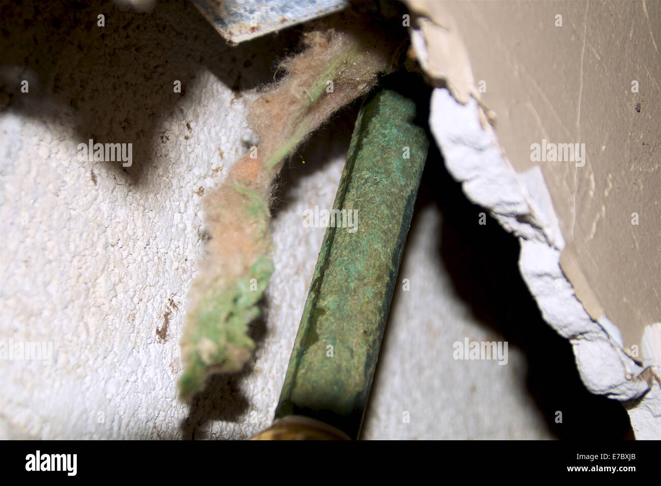 Close up of an old corroded leaking copper pipe inside wall Stock Photo
