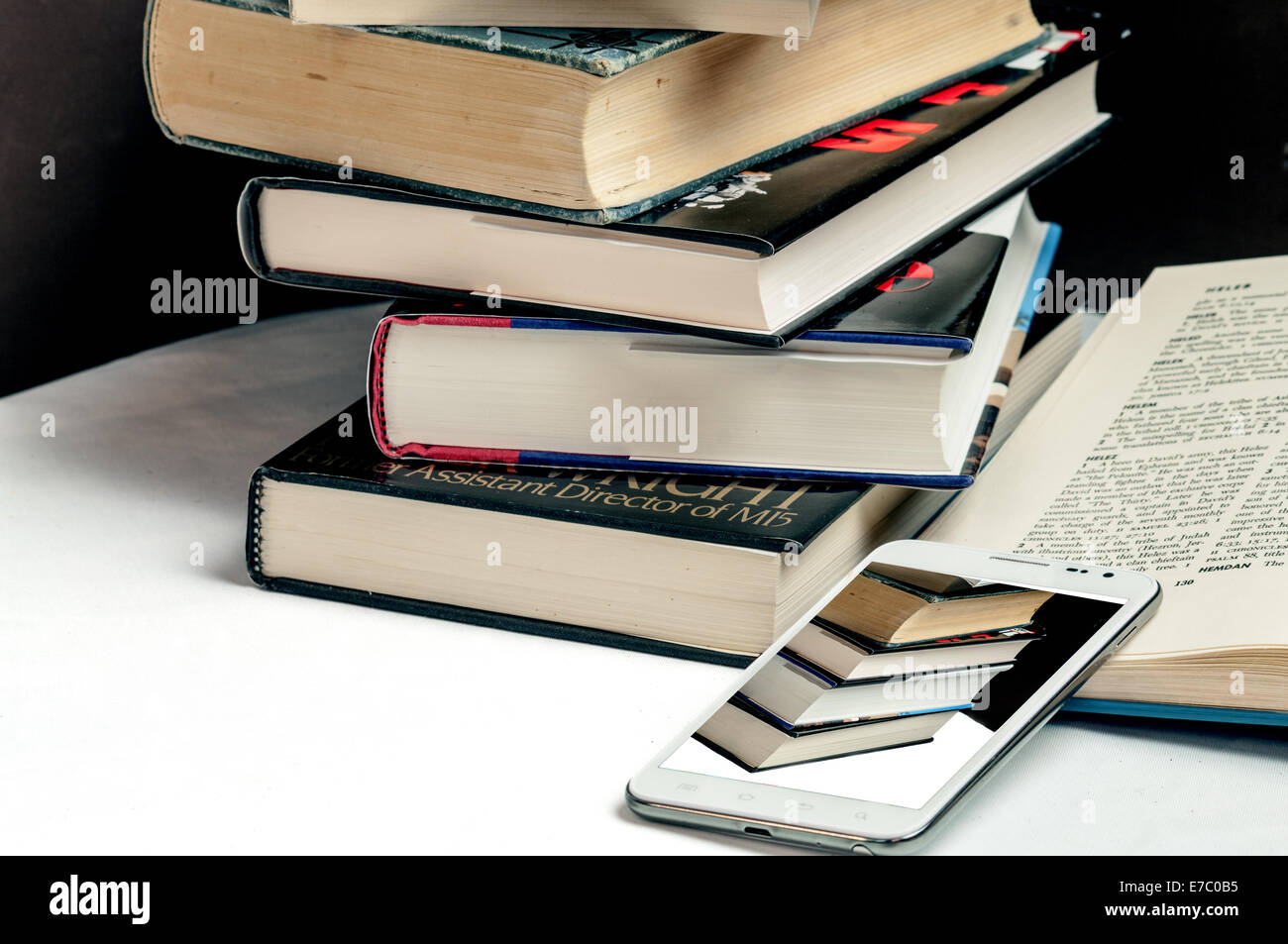 Smart-phone and books demonstrating changes in technology Stock Photo