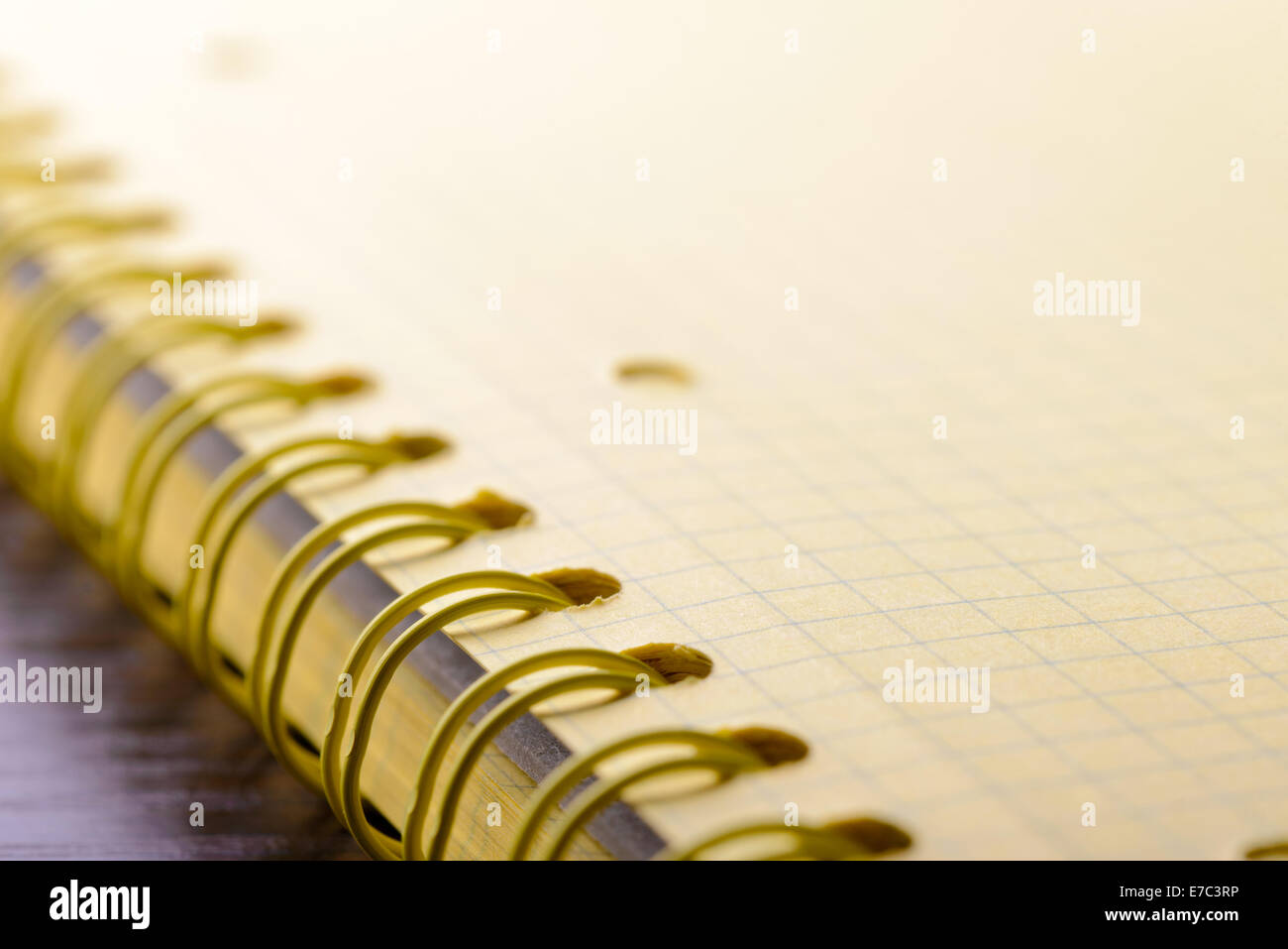 Macro of the spiral of a yellow paper notebook with short deep of field Stock Photo
