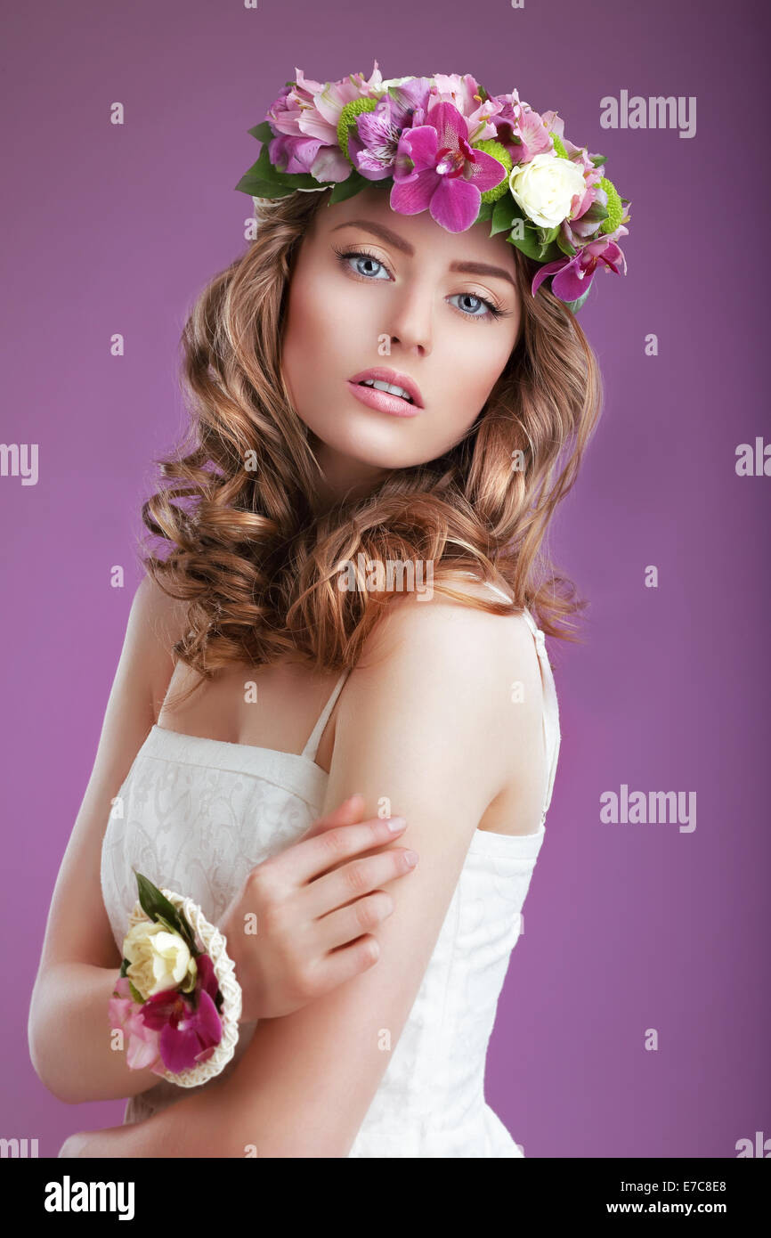 Exquisite Woman with Wreath of Flowers. Elegant Lady with Frizzy Hair Stock Photo