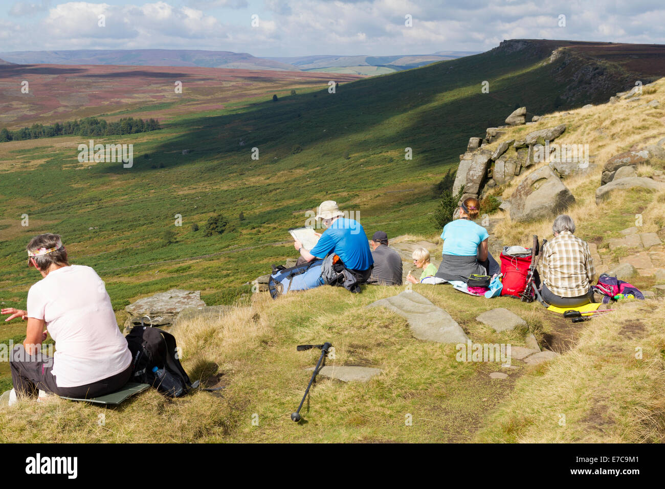 A group of walkers sitting on Stanage Edge and eating lunch Stock Photo