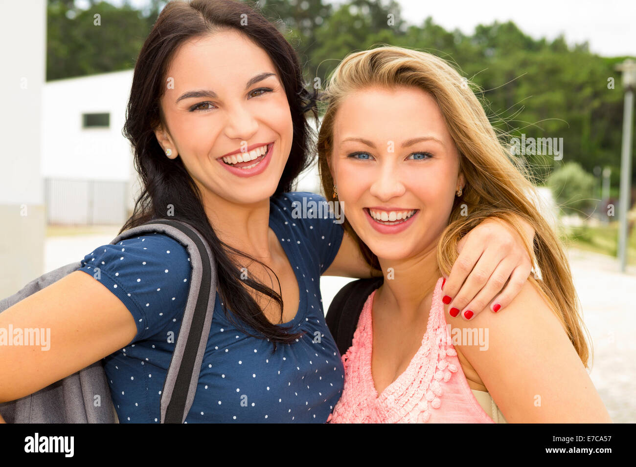 Two beautiful and happy teenage students lauthing Stock Photo - Alamy