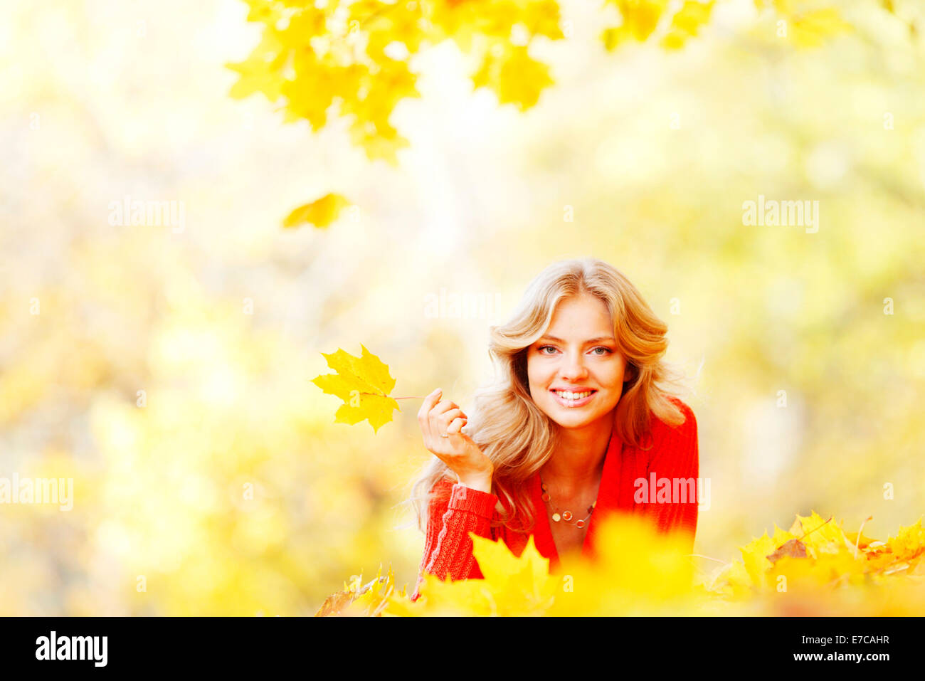 Happy young woman laying on autumn leaves in park Stock Photo - Alamy