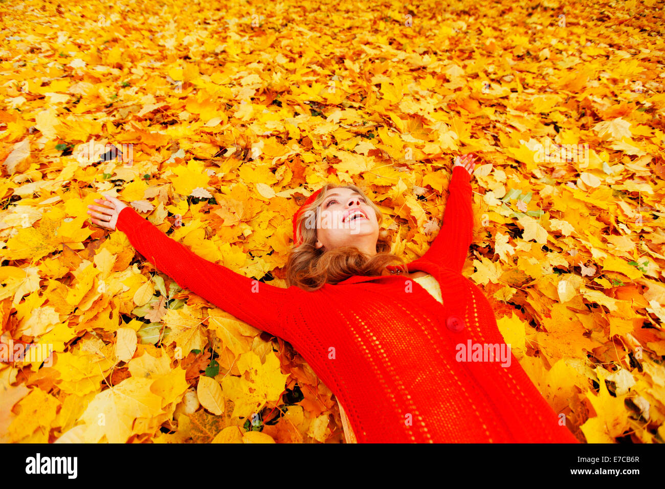 Happy young woman laying on autumn leaves in park Stock Photo - Alamy