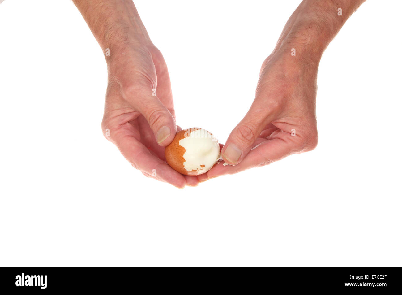 Pair of hands peeling a hardboiled egg isolated against white Stock Photo