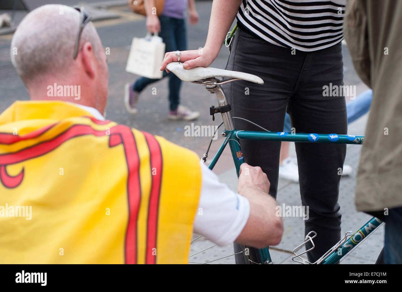 Glasgow, Scotland, UK. 13th September, 2014. A yes supporter puts yes stickers on a girls bike during the lead up to the Scottish independence referendum on Buchanan Street, Glasgow, Scotland on Saturday 13th September 2014 Credit:  Iona Shepherd/Alamy Live News Stock Photo
