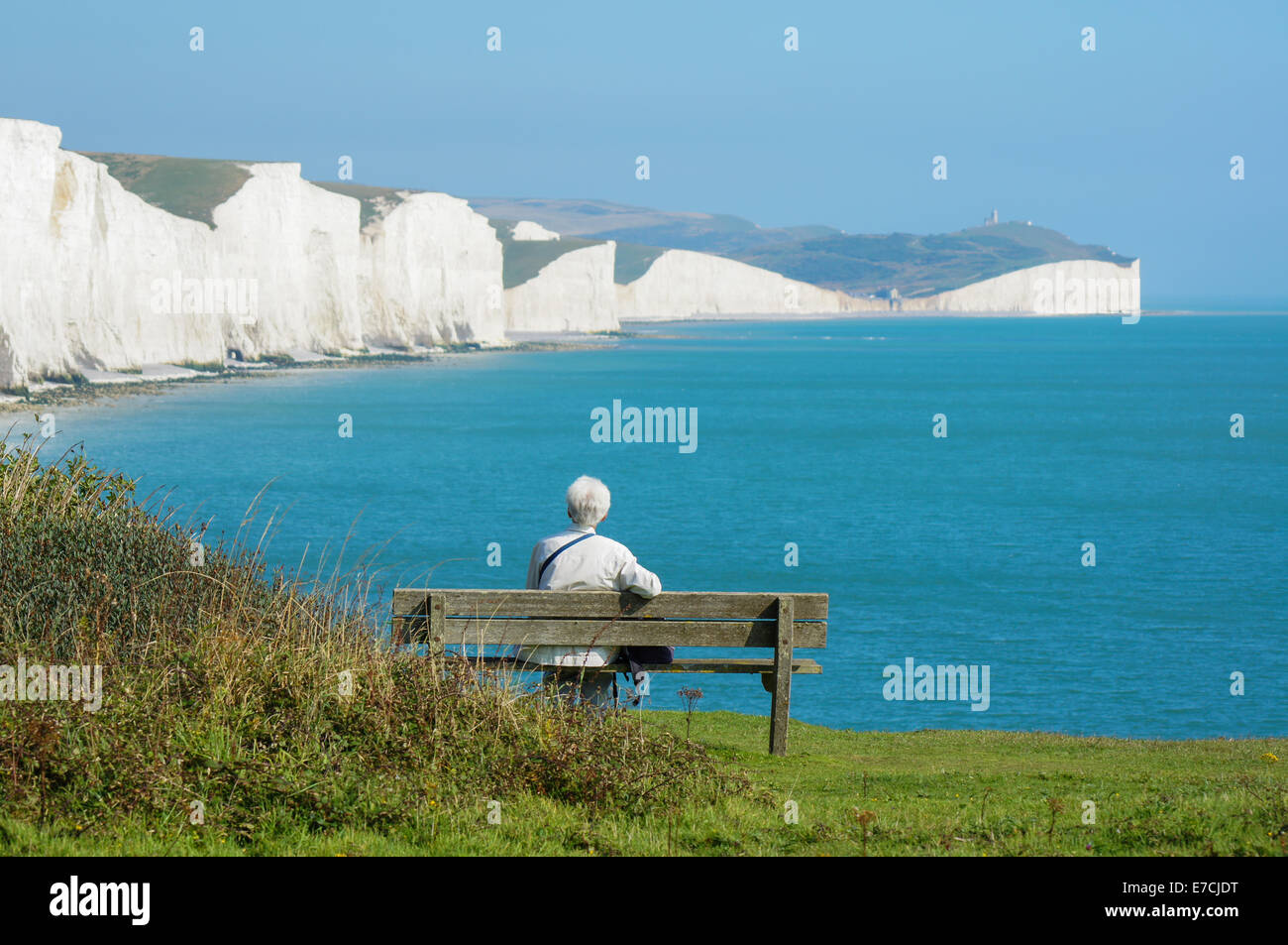 Visitor at Seaford Head looking towards Seven Sisters chalk cliffs,  South Downs Way, South Downs National Park, East Sussex England United Kingdom UK Stock Photo