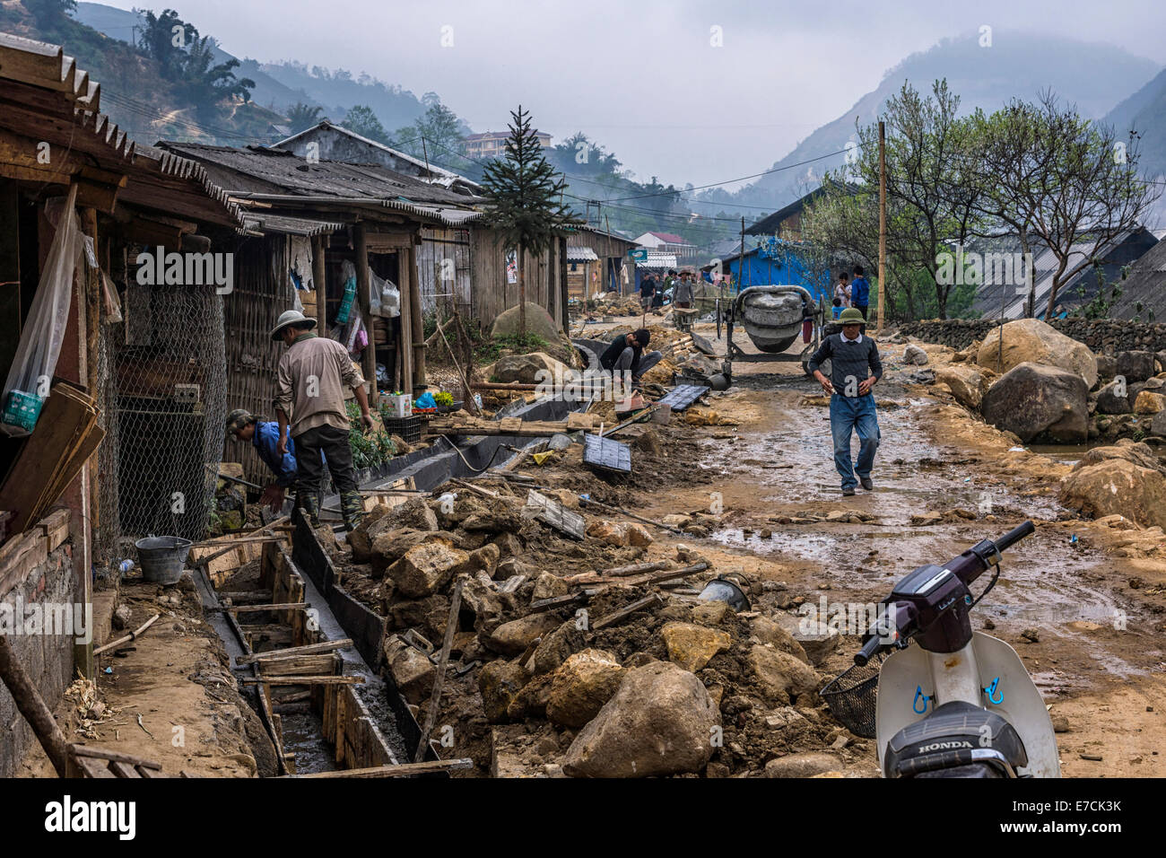 Messy scene with laborers constructing a sewer along the rural road in Lao Chai. Stock Photo