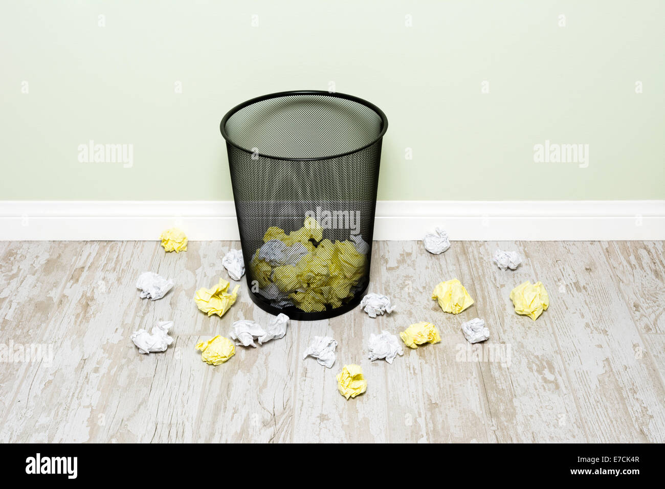 Wads of crumpled up paper scattered in and around a trashcan shows the frustration of an office worker. Image can be easily crop Stock Photo