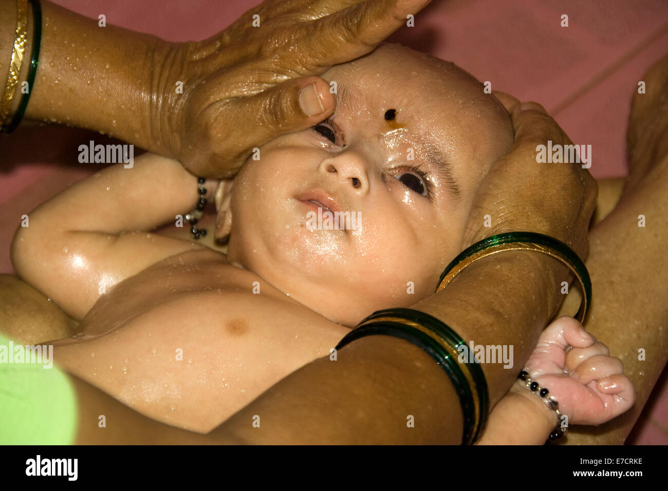 Baby’s hot water bath with copious oil massage Stock Photo