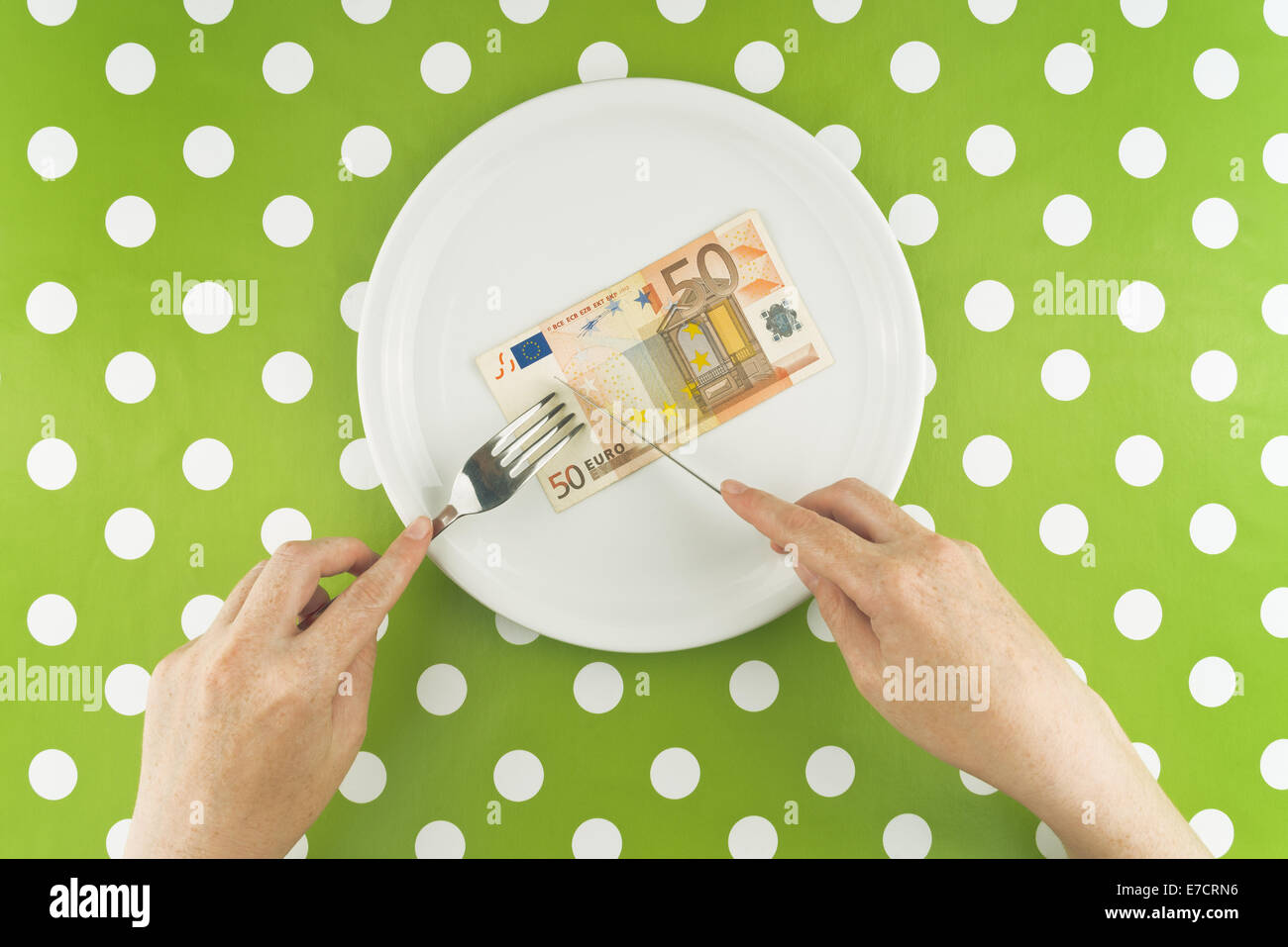 Woman eating fifty euros banknote for dinner, top view Stock Photo