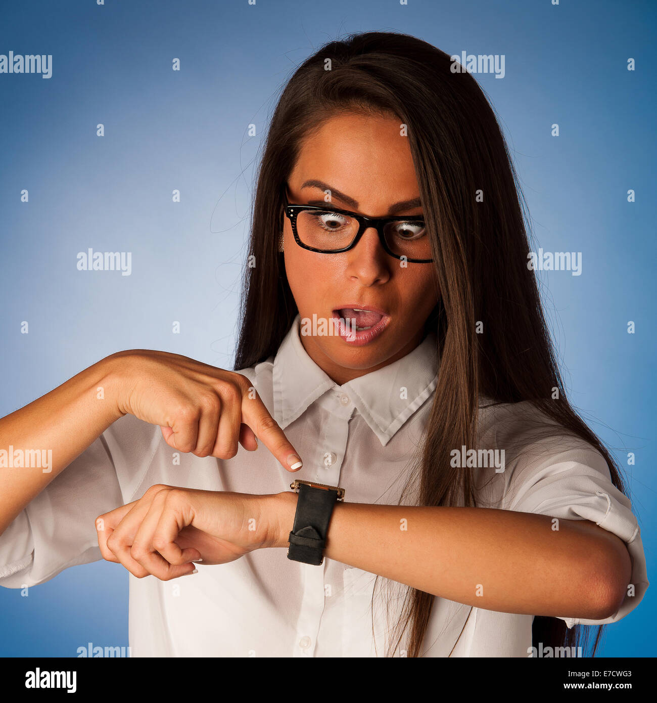 stressed woman staring into watch gesturing being late Stock Photo