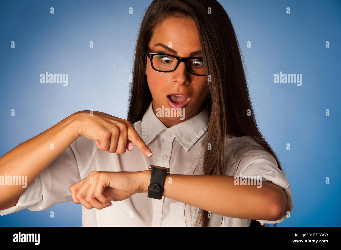 stressed woman staring into watch gesturing being late Stock Photo