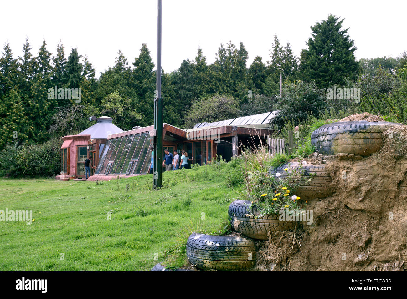 The Brighton Earthship with, in the foreground, an example of how an earthship wall is constructed of vehicle tyres and earth. Stock Photo