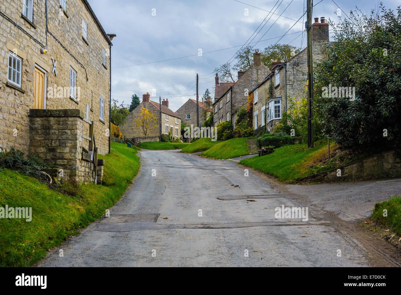 Looking up a narrow lane street road in the charming, rural North Yorkshire village of Nunnington; horizontal landscape format Stock Photo
